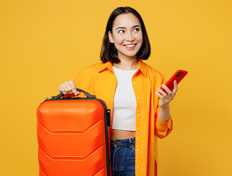 Immagine fotografica di una donna con una valigia e un cellulare in mano