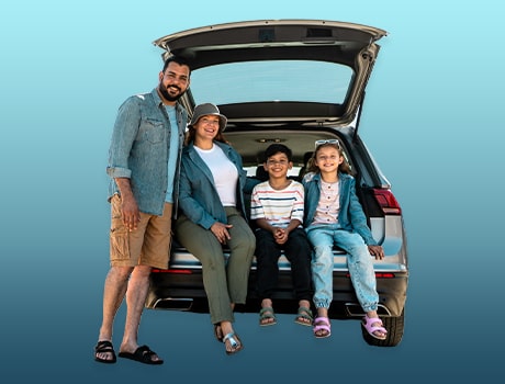 Immagine fotografica di una giovane coppia con figli accanto alla propria autevettura durante una sosta