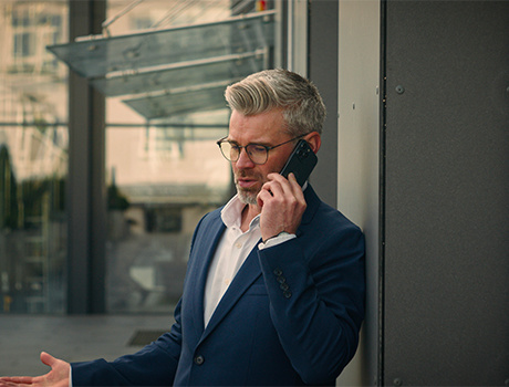 Un uomo al telefono con aria un po' preoccupata