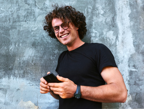 Immagine fotografica di un ragazzo con un cellulare in mano